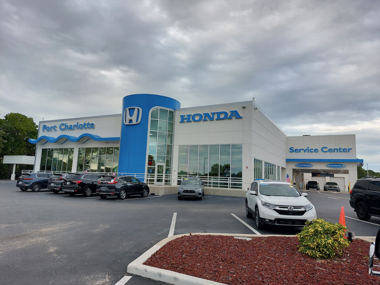 A honda dealership with cars parked in front of it
