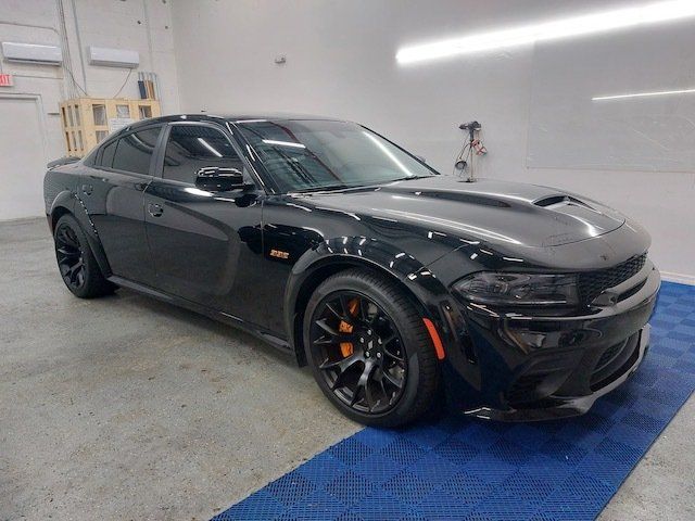 A black dodge charger is parked in a garage.