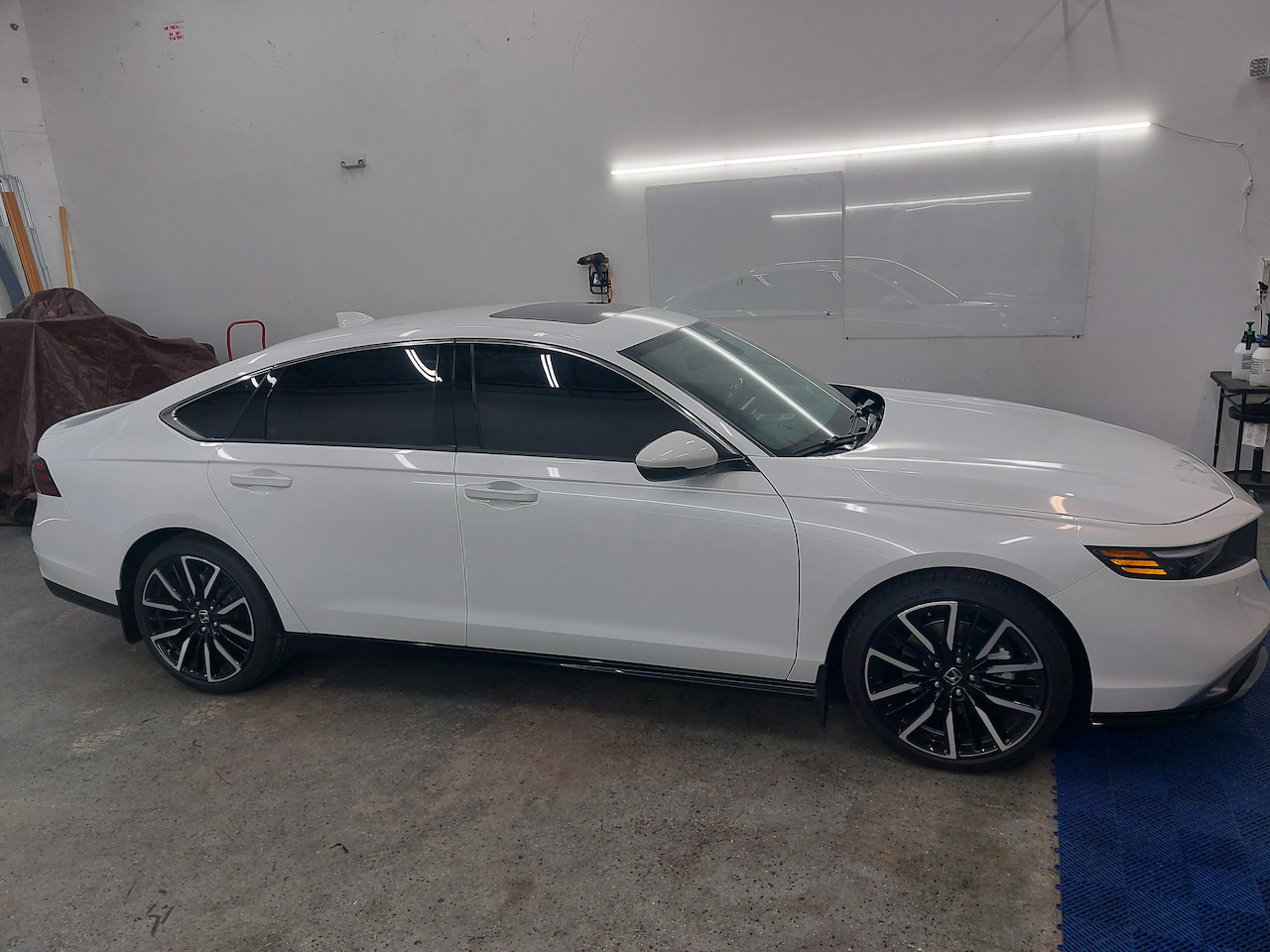A white car is parked in a garage.