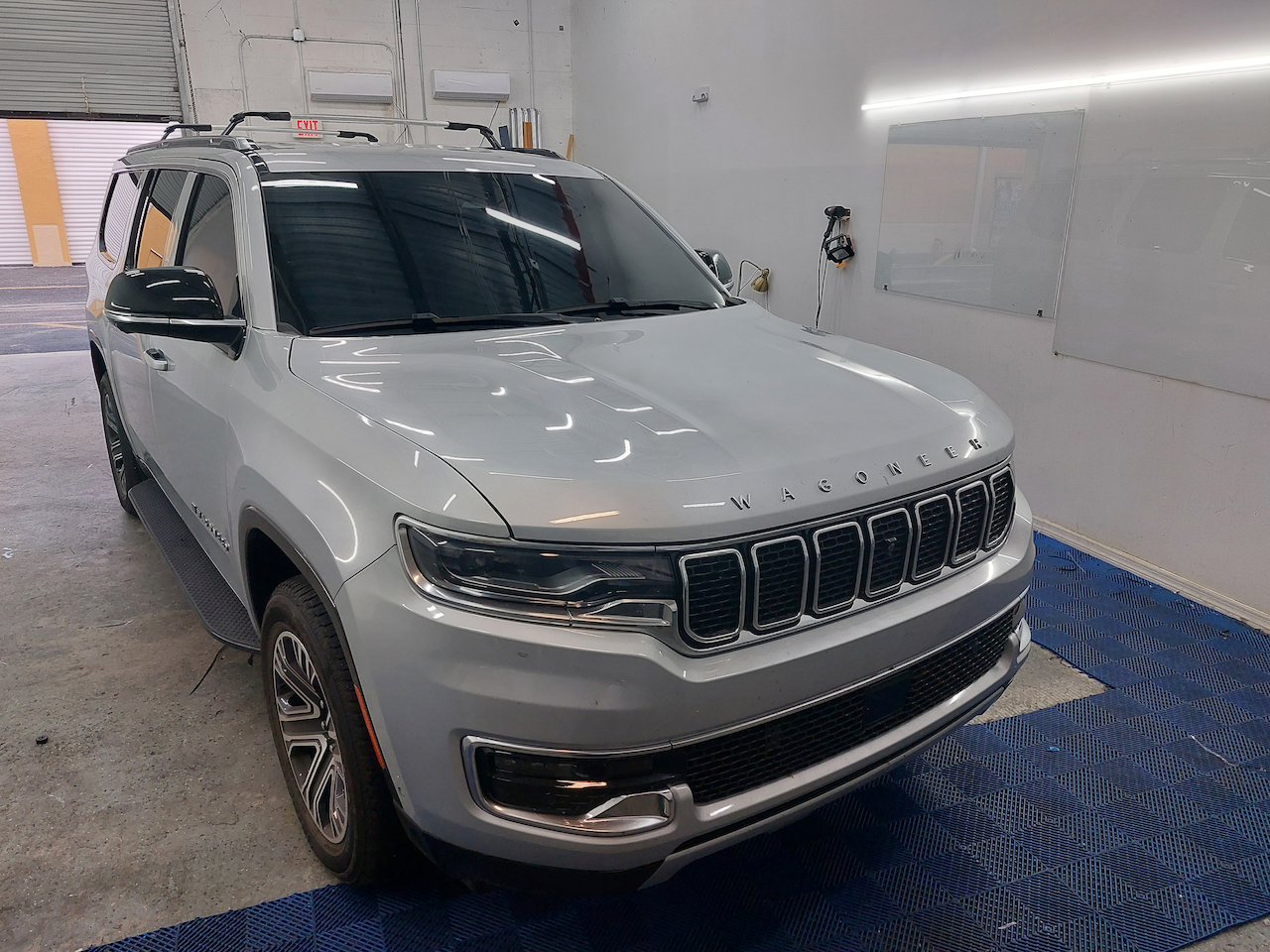 A white jeep grand cherokee is parked in a garage.