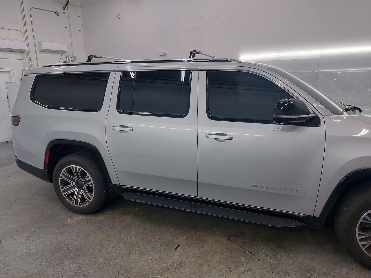 A silver suv is parked in a garage.