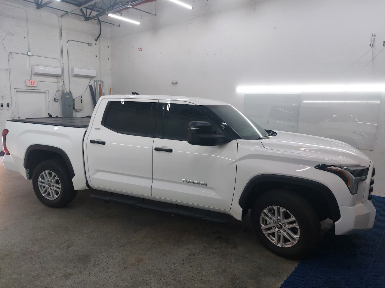 A white truck is parked in a garage.