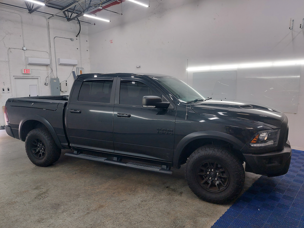 A black dodge ram truck is parked in a garage.