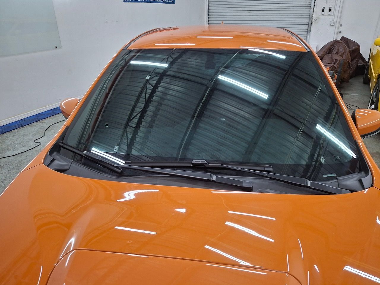 A close up of a car 's windshield in a garage.