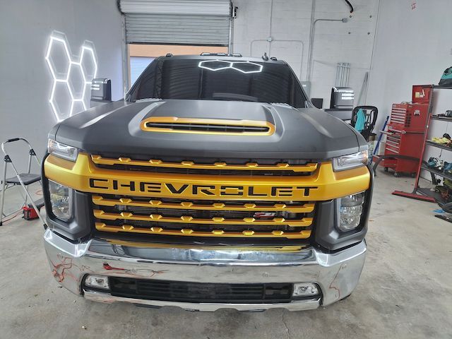 A black and gold chevrolet truck is parked in a garage.