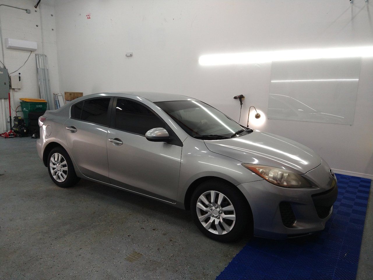 A silver car is parked in a garage.