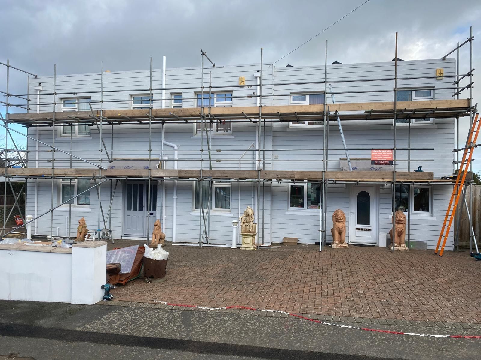 A home with new weatherboard cladding fitted, and scaffolding in front.