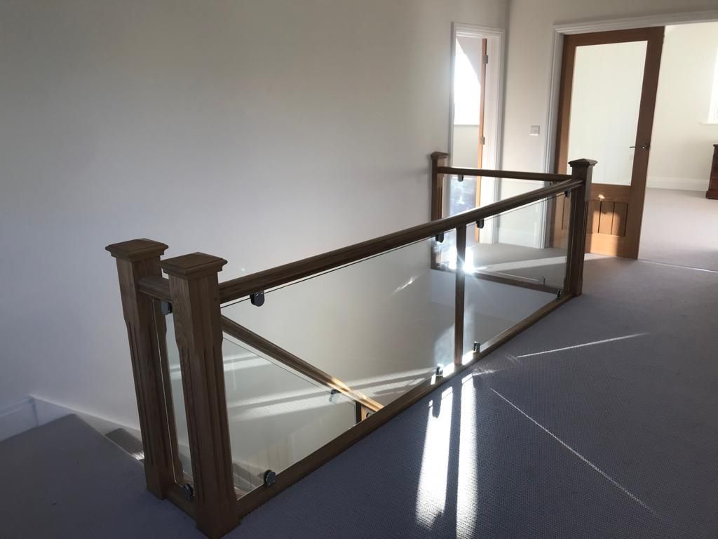 A staircase with a wooden railing and a glass railing