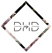 Black diamond with floral design framing the letters 