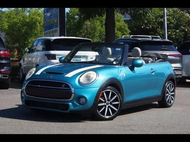 Blue Mini Cooper convertible parked in a lot, with its top down. | iDeal Auto Service