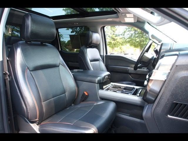Luxury SUV interior with black leather seats and a center console, viewed from the back seat | iDeal Auto Service