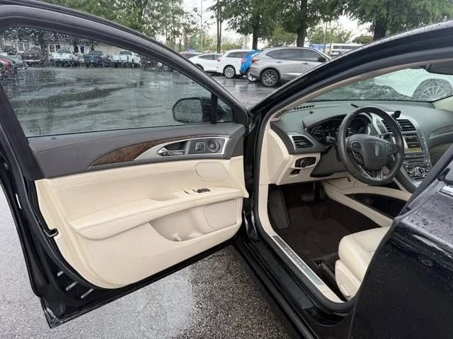 Open black car with beige interior, showing front seats and dashboard in a parking lot. | iDeal Auto Service