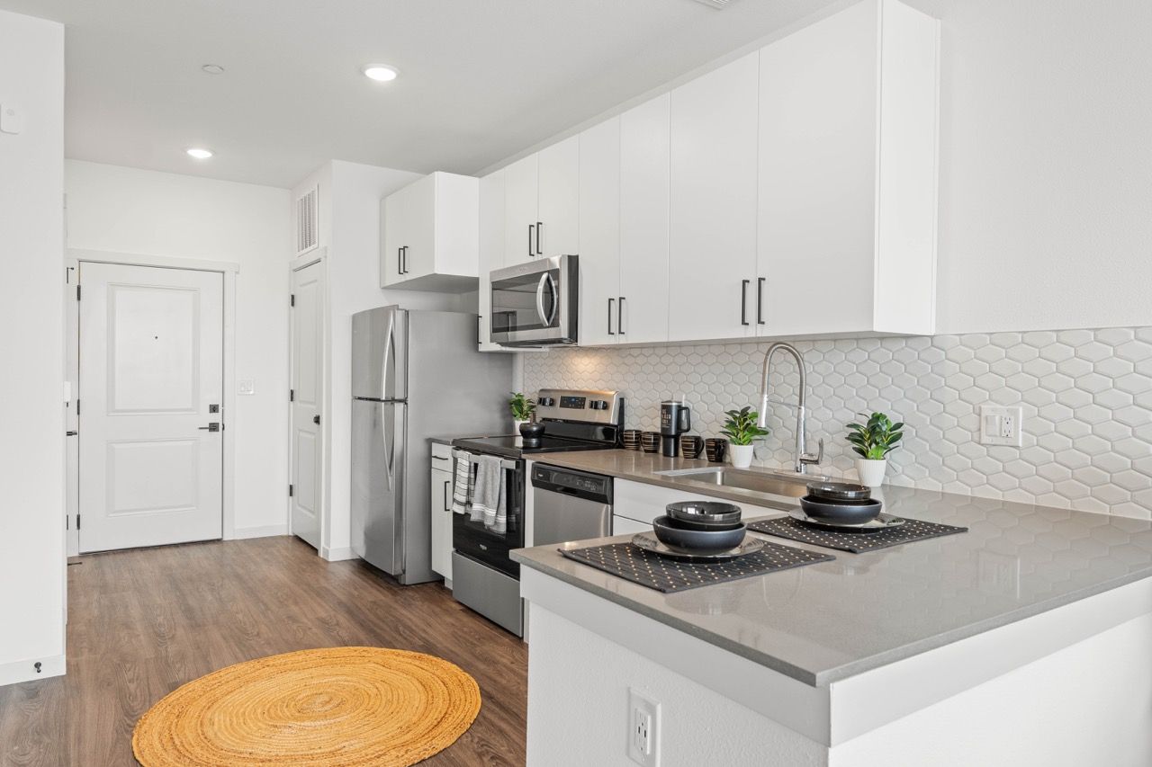 Bright modern kitchen with white cabinets, stainless-steel appliances, and an island.