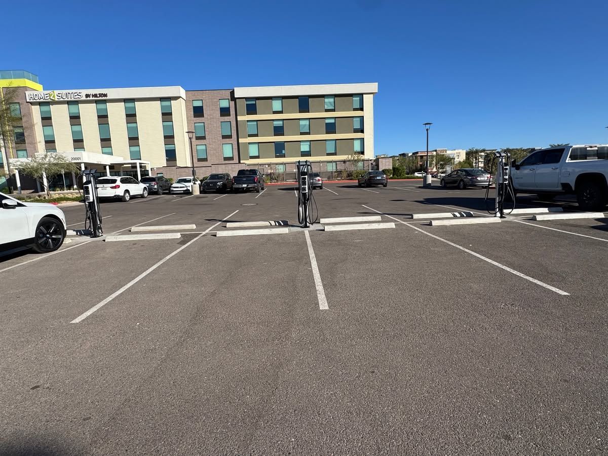 Parking lot in front of a beige hotel under a clear blue sky