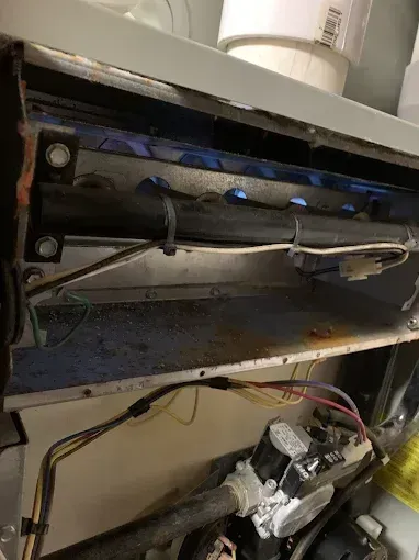 Under-shelf wiring and a metal control panel inside a cabinet, with wires and components exposed