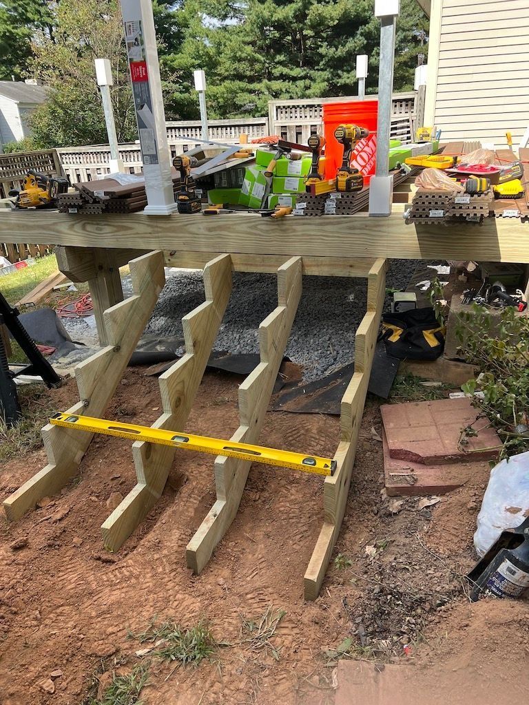 Broken wooden fence with yellow tape in a garden area near benches and potted flowers