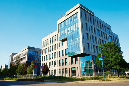 Modern office buildings with glass facades on a sunny street corner