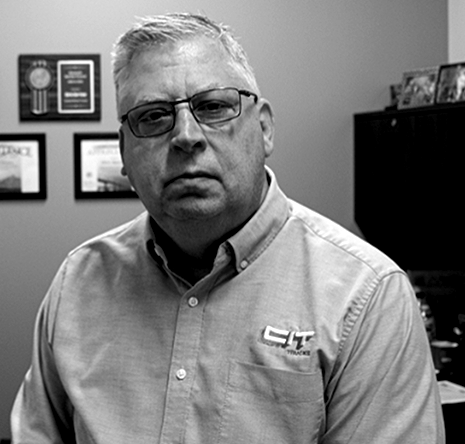 A black and white photo of a man wearing glasses and a shirt that says cit.