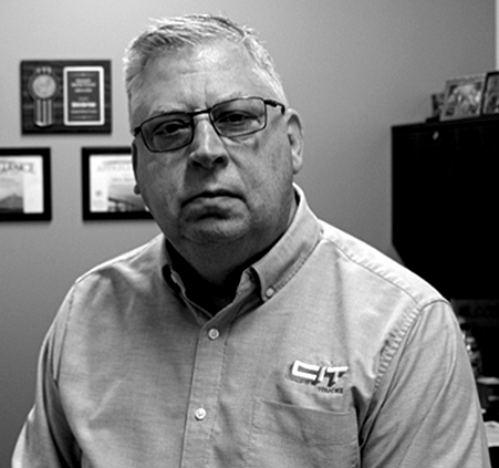 A black and white photo of a man wearing glasses and a shirt that says cit.