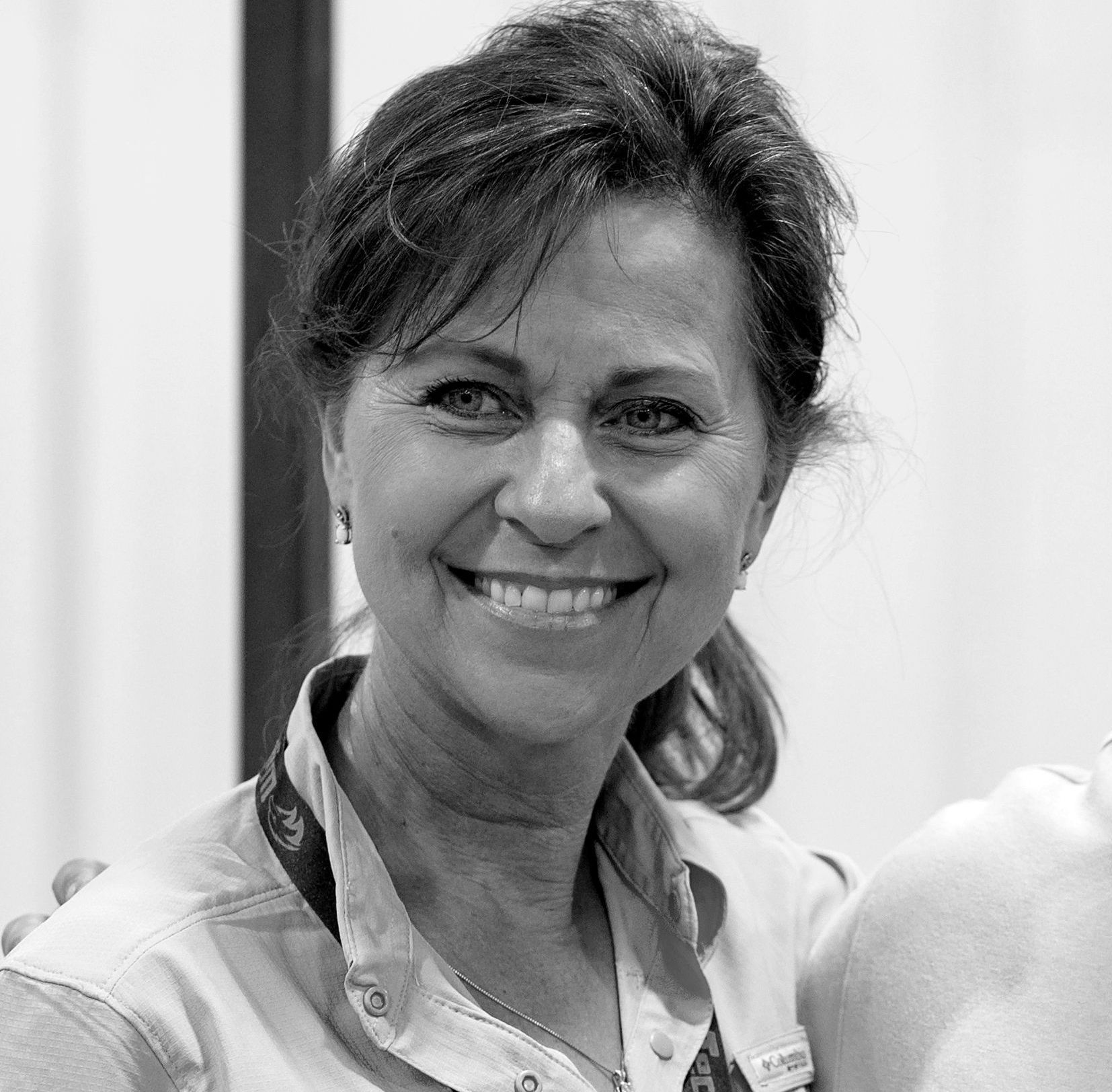A woman is smiling in a black and white photo.