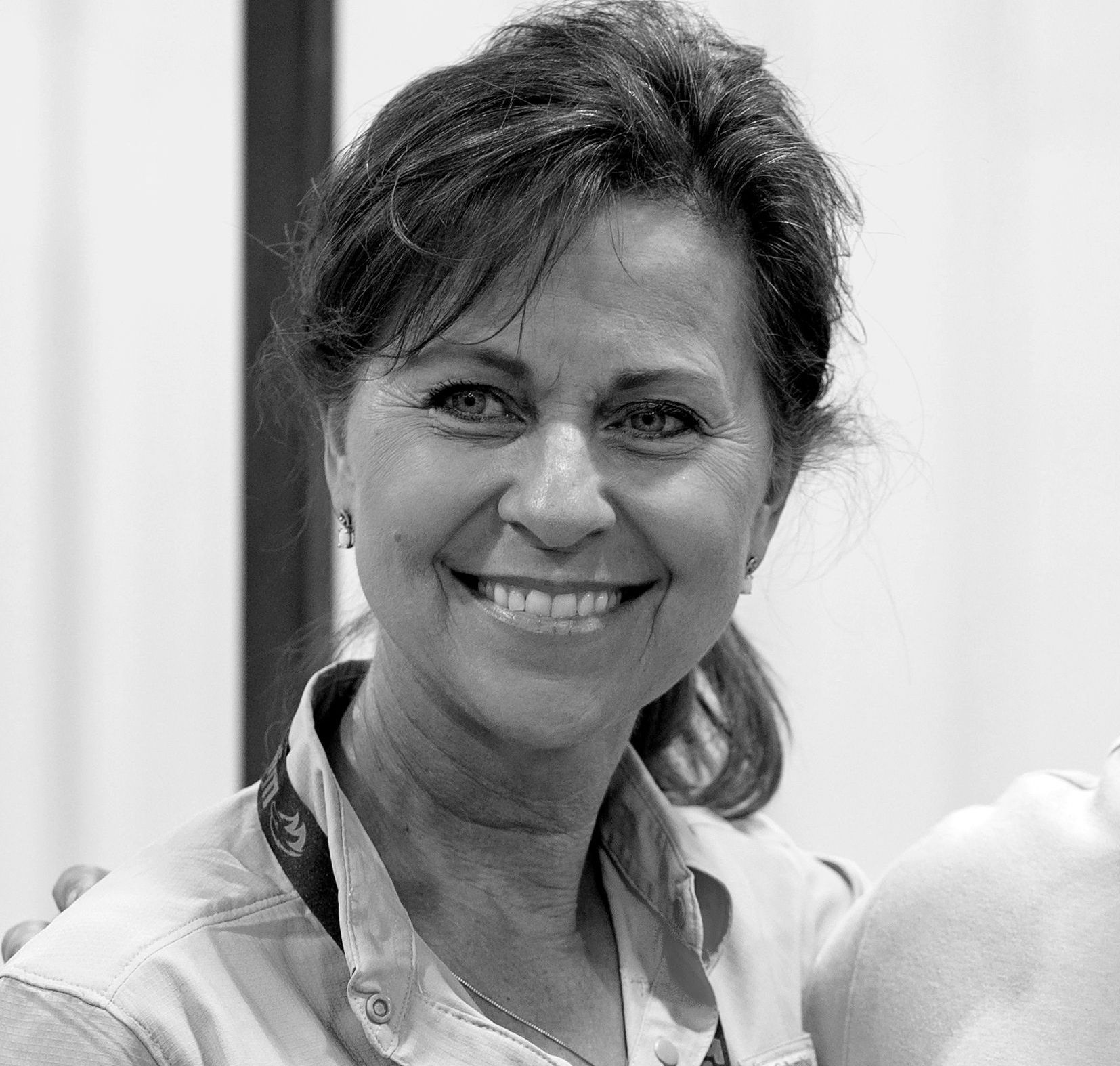 A woman is smiling in a black and white photo.
