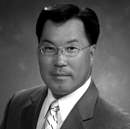 A man in a suit and tie is wearing glasses.