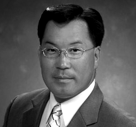 A man in a suit and tie is wearing glasses.