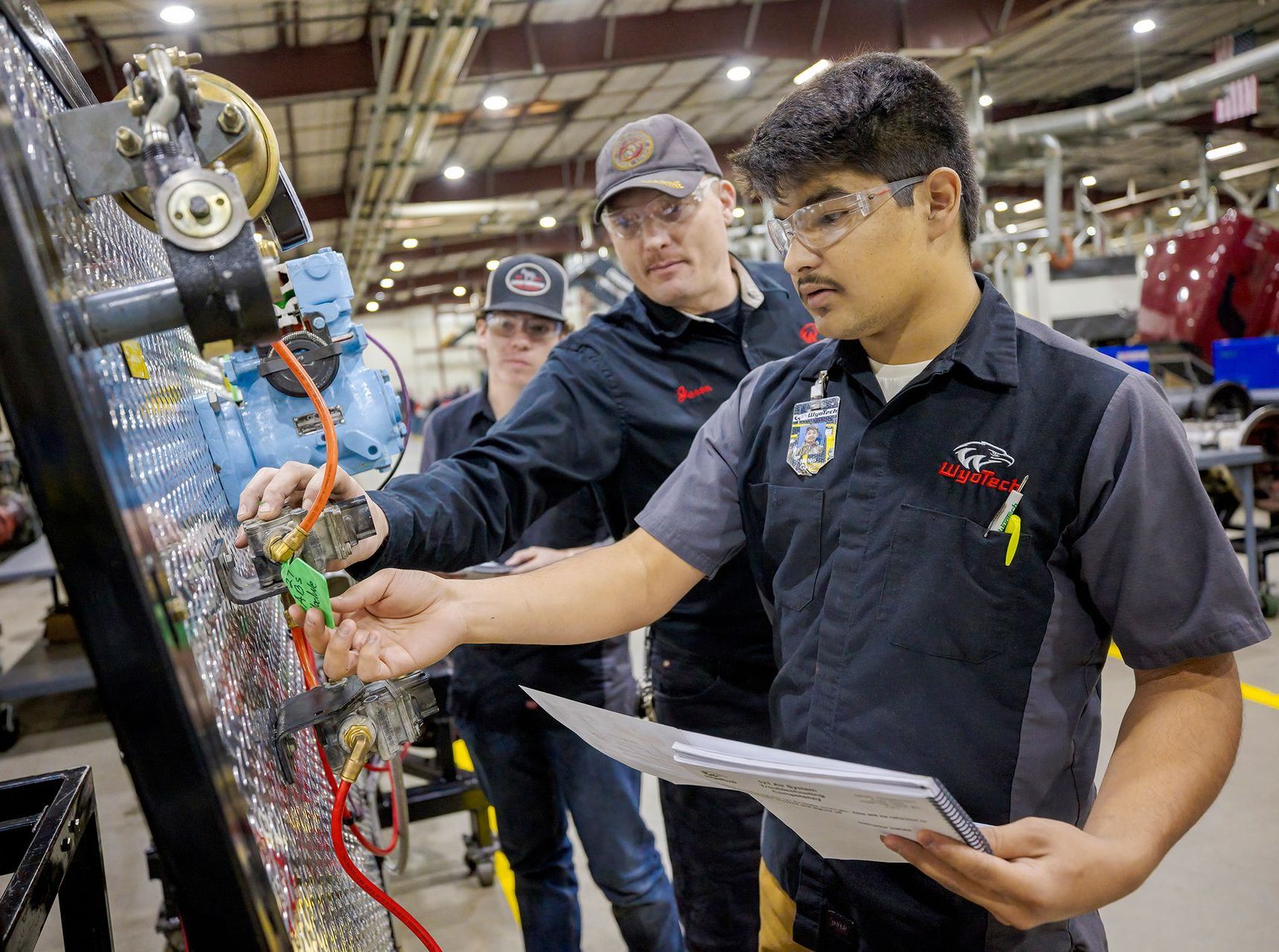 A group of men are working on a machine in a factory.