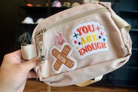 Tan fanny pack with patches, including a bunny and 