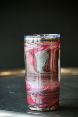 Marble-patterned tumbler with red, silver, and brown swirls, topped with a clear lid.