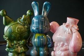 Three colorful bunny sculptures with dripped paint effects.