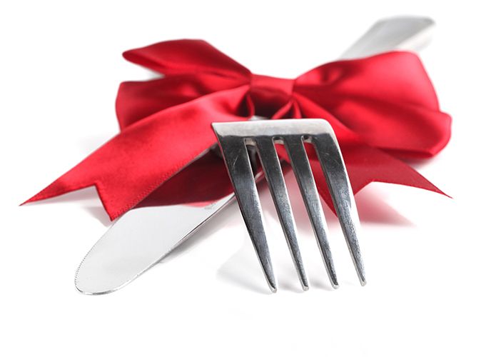 Fork and knife tied with a red ribbon, suggesting a food-related gift.