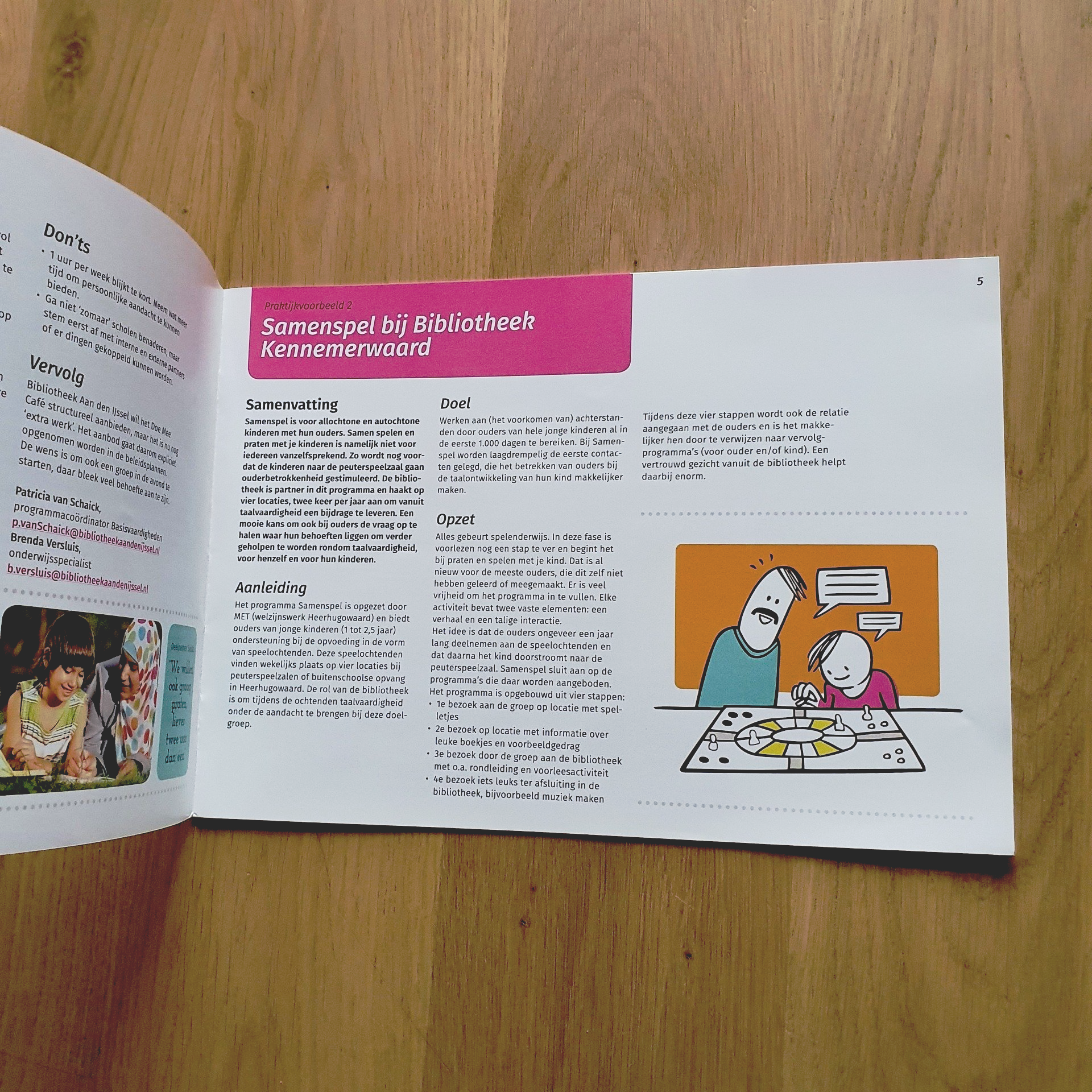Open boek op een houten ondergrond. Illustratie van een volwassene en een kind, mogelijk spelend een spel. Tekst op de pagina.