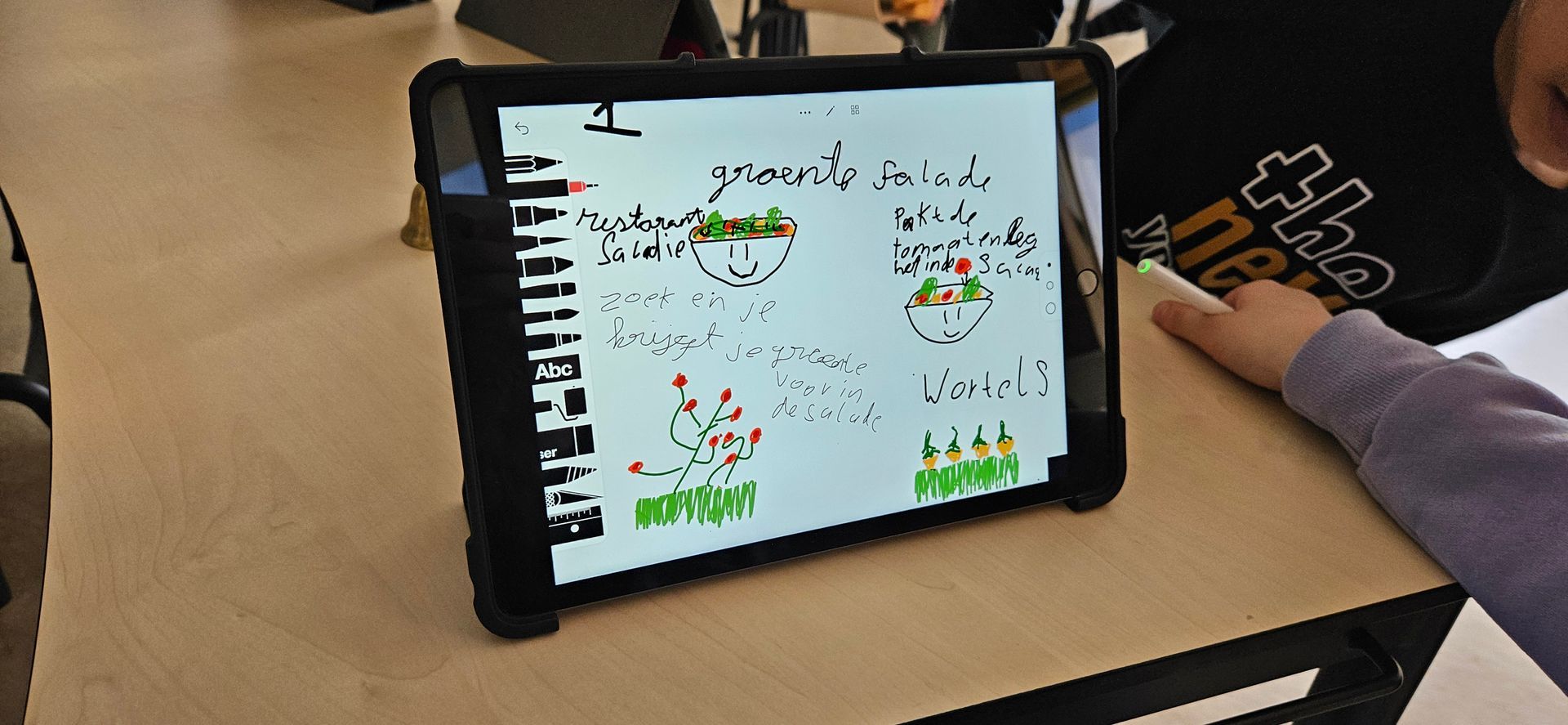 Op een tablet wordt een tekening van planten weergegeven. Iemand gebruikt een stylus om met de tablet te interageren.