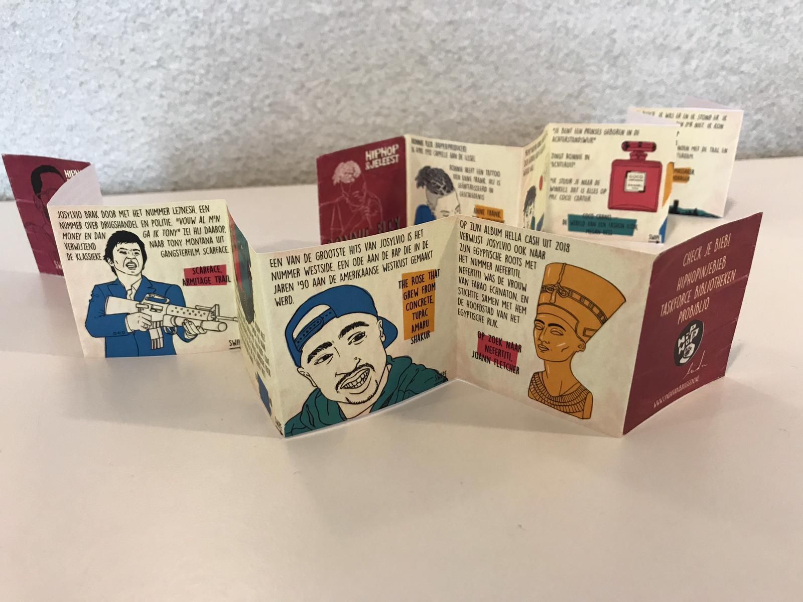 Een accordeonachtig papieren boek met tekeningen van beroemde figuren en citaten.