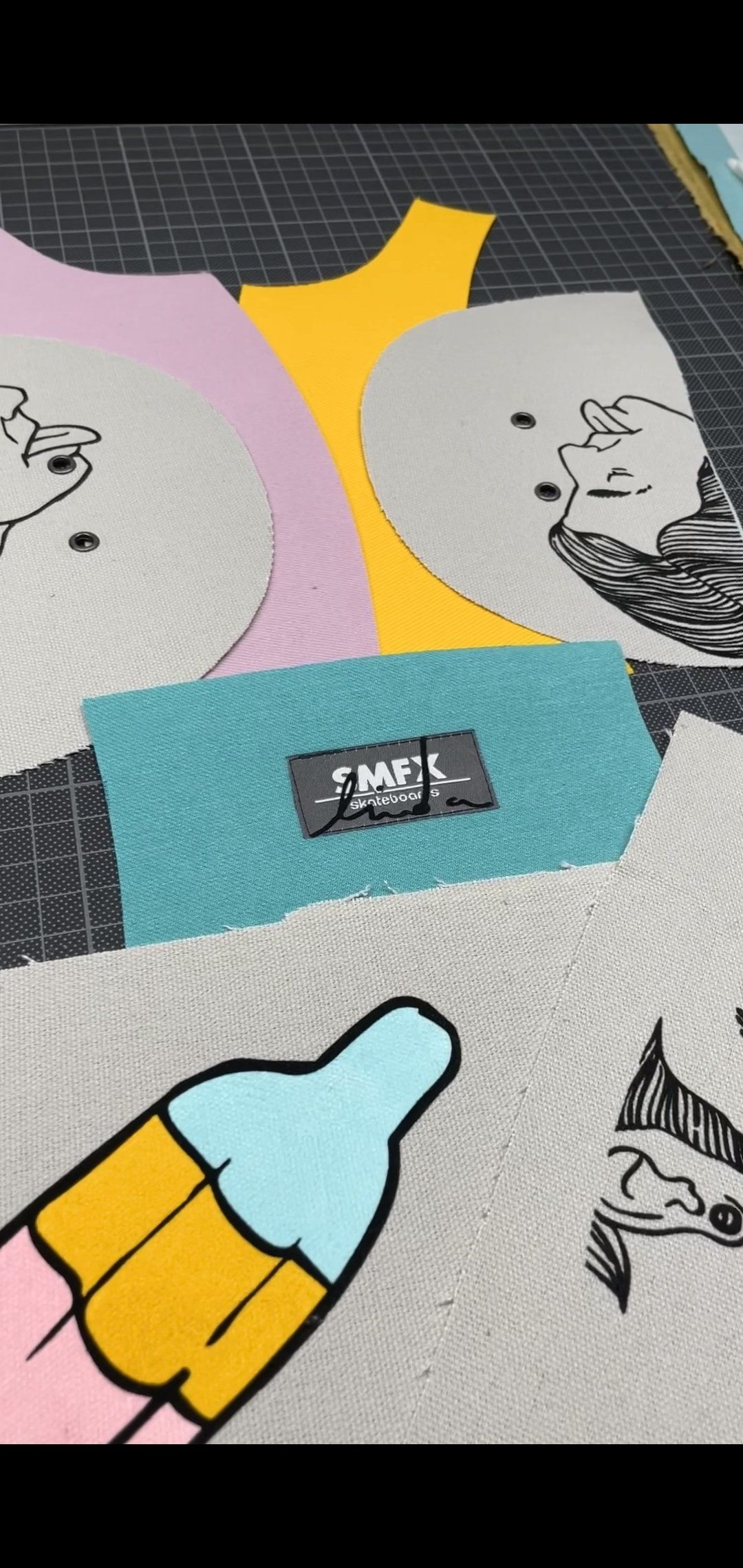 Naaiproject met kleurrijke stoffen stukjes, een turquoise rechthoek en een zwart apparaat op een zwarte ondergrond.