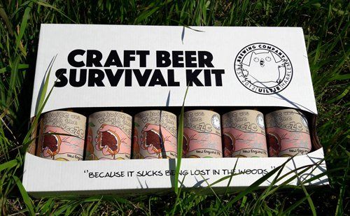 Een overlevingspakket voor ambachtelijk bier in een doos met zes blikjes, buiten in het gras. Op de doos staat de tekst 