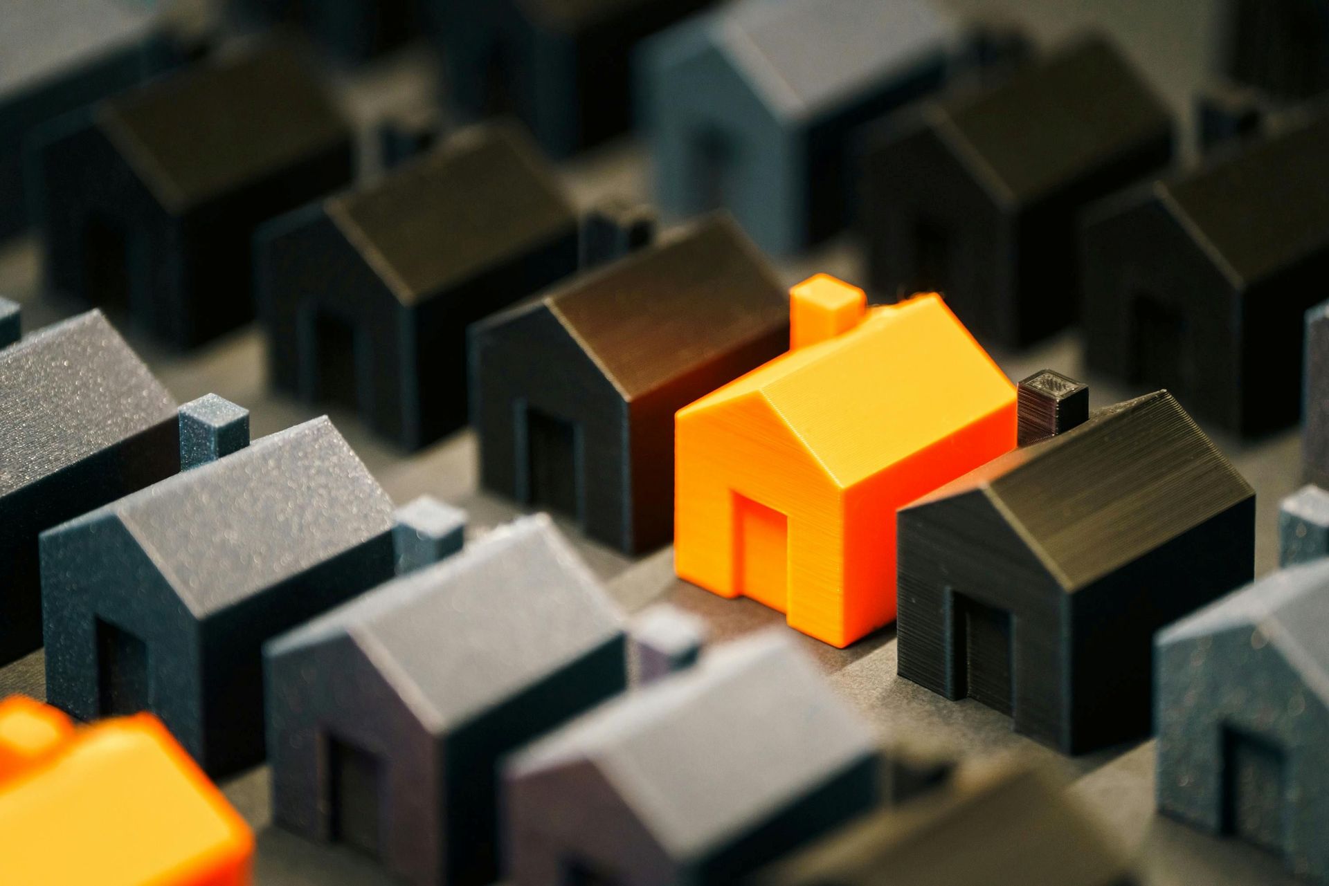 Orange block house among black and gray block houses