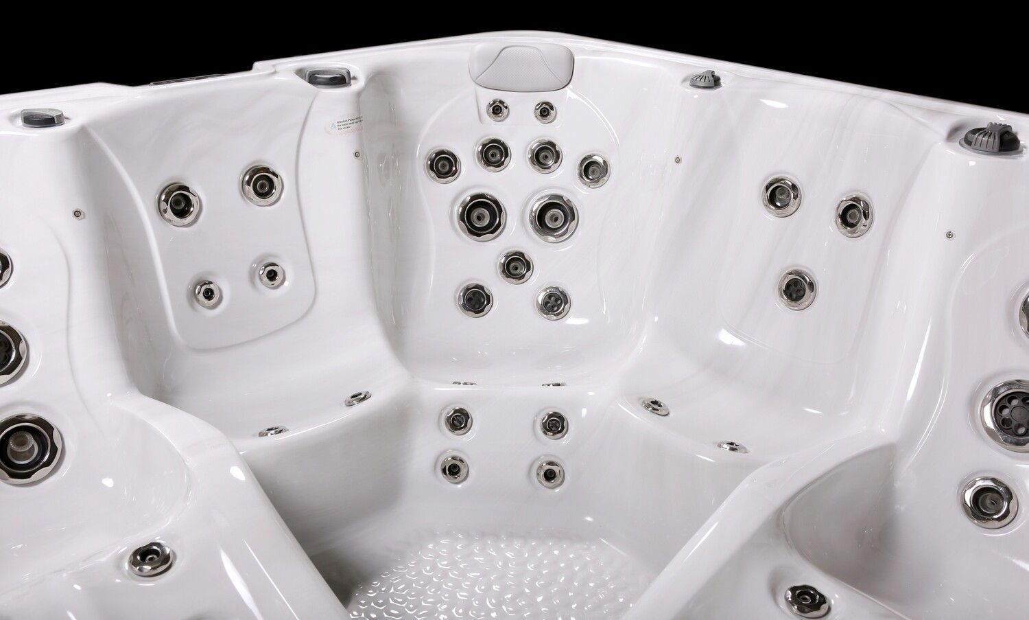 White hot tub interior with multiple jets, against a dark background.