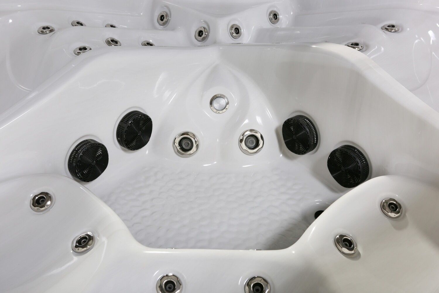 White hot tub interior with several jets and seating areas.