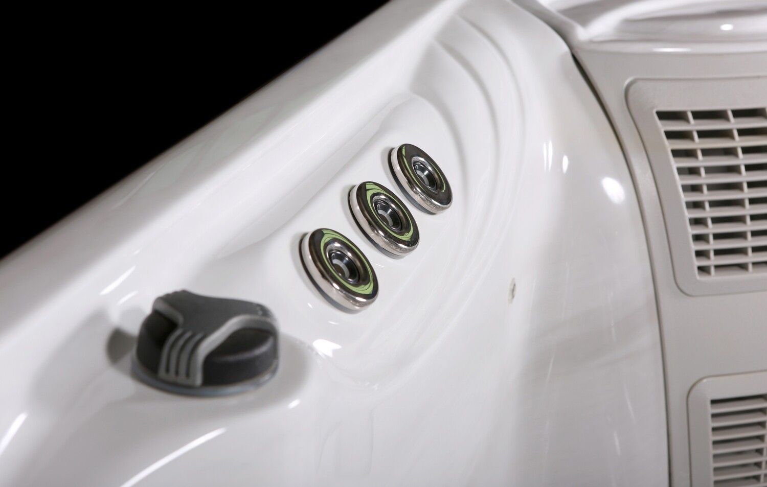 White hot tub interior with three jets and a directional knob.