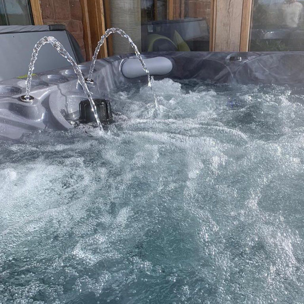 Hot tub with water jets spraying into churning water.