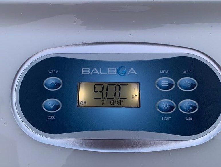 Hot tub control panel with digital display showing 90.0 degrees, buttons for warm, cool, jets, light, and mode.