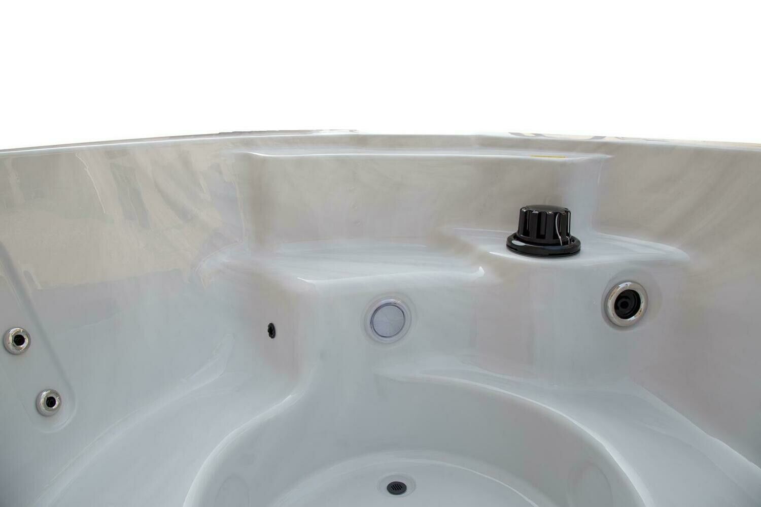 Close-up of the interior of a white hot tub, showing jets and control knob.