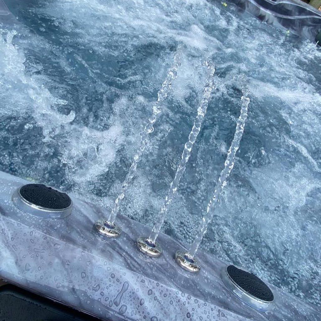 Jets of water spraying upwards from a hot tub, bubbling water.