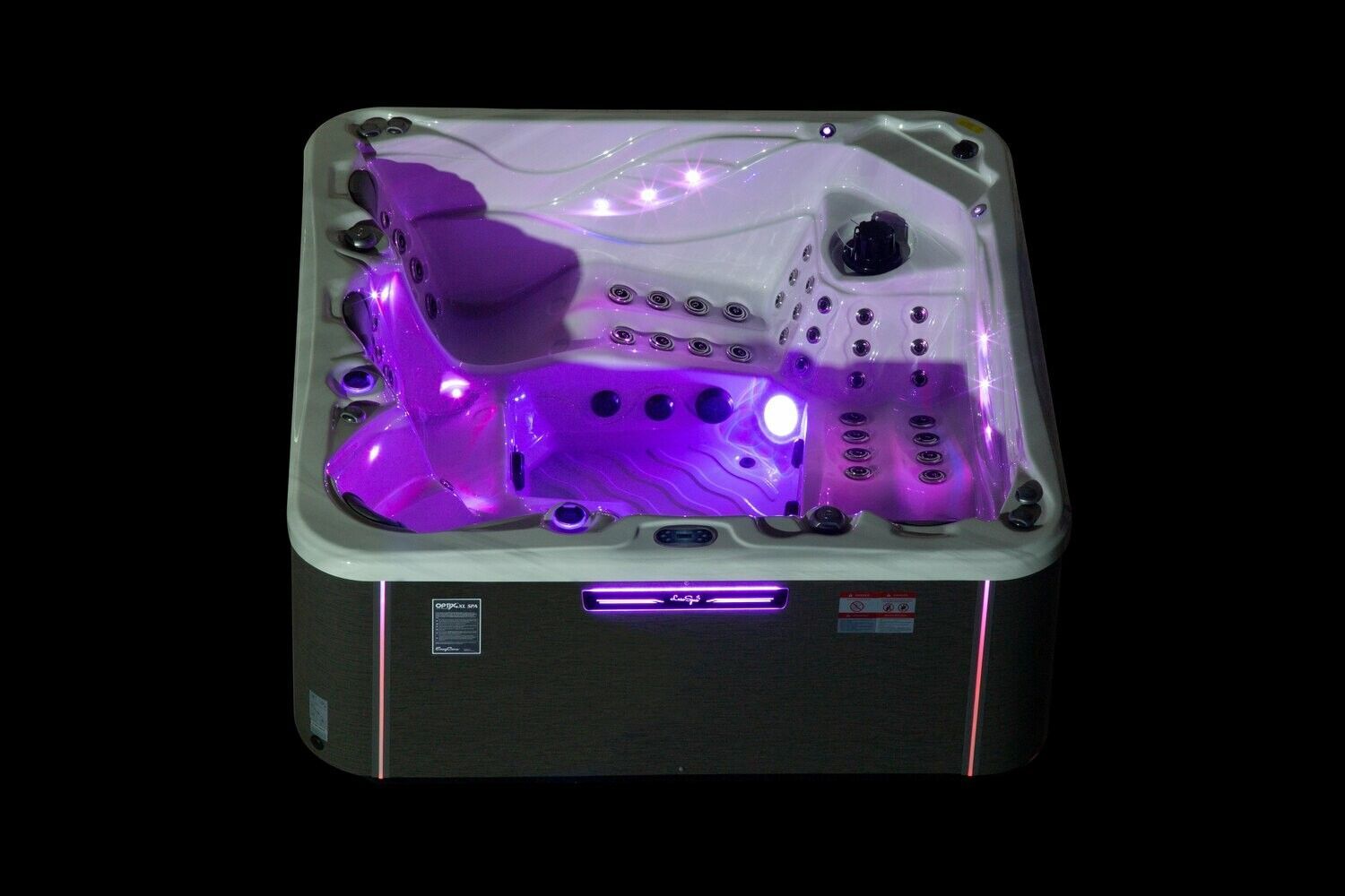 Illuminated hot tub with purple lights, nozzles, and seating against a black backdrop.