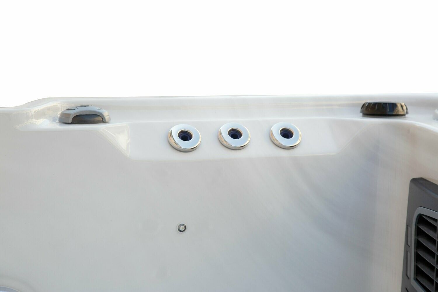 Close-up of a white hot tub, showing three silver water jets and control buttons on the side.