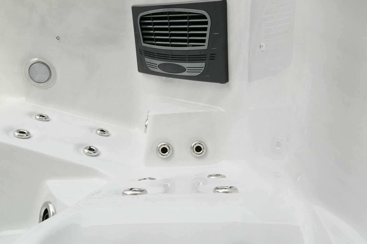 Interior of a white hot tub, showing jets, control panel, and vent.
