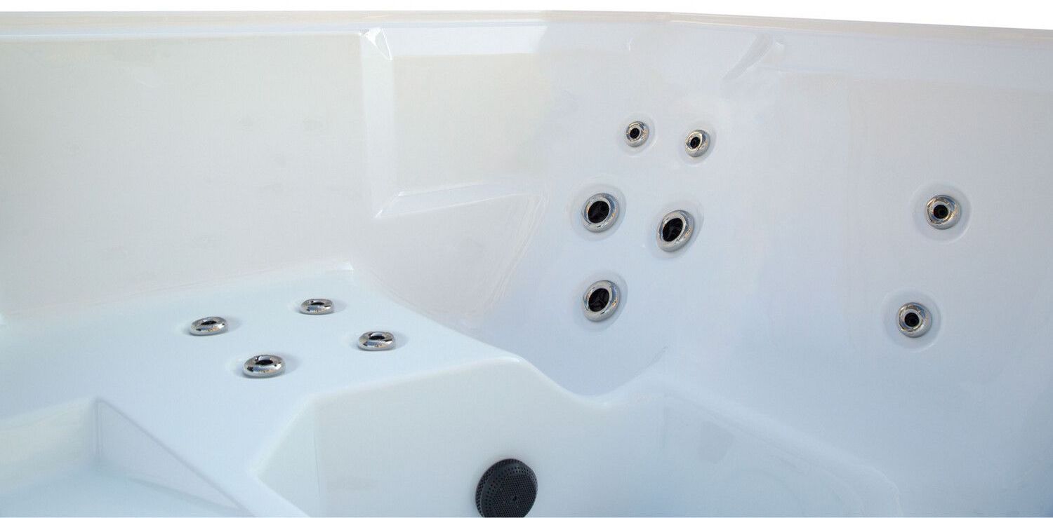 Close-up of a white hot tub interior with several water jets.