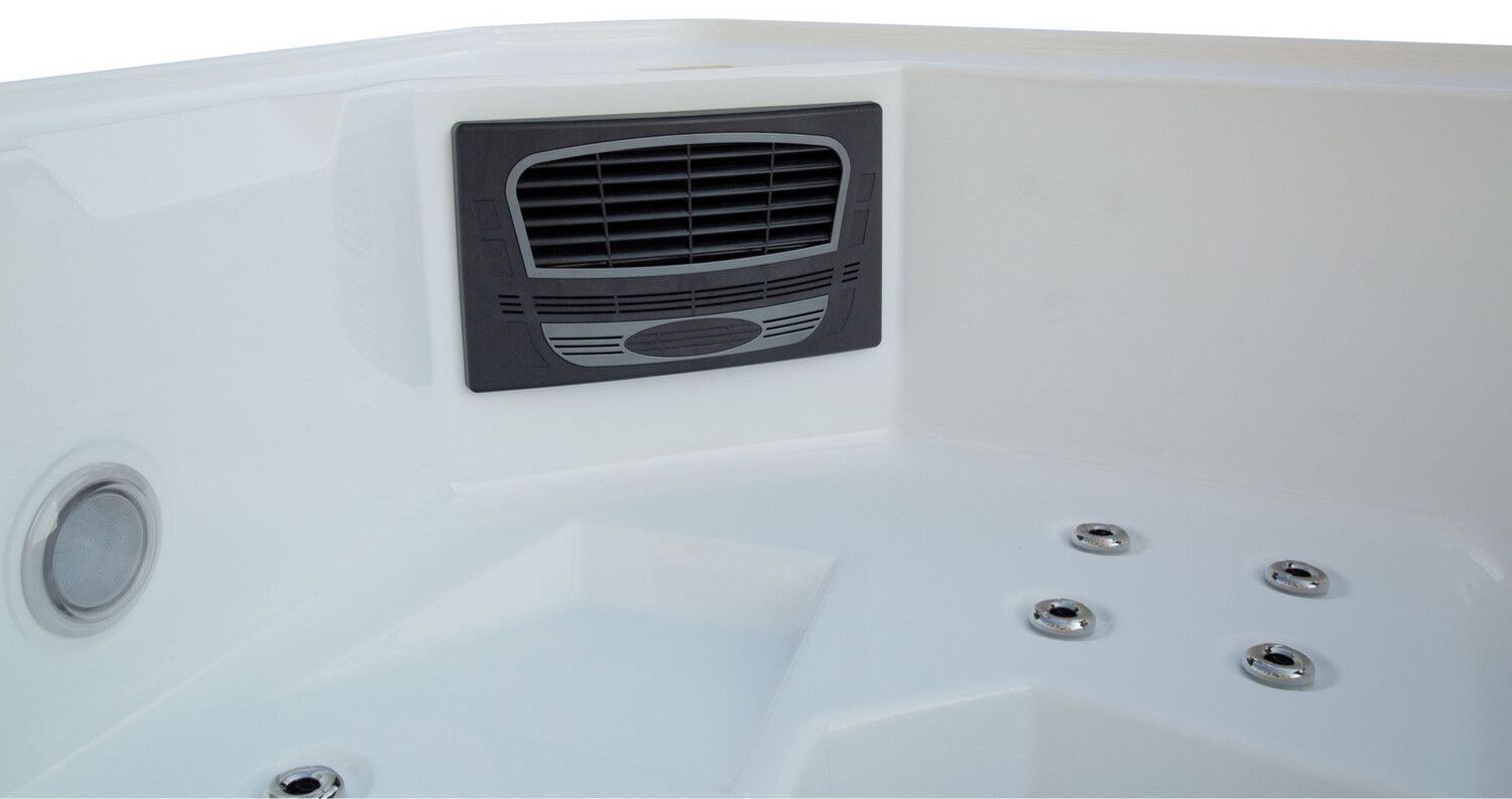 Close-up of a white hot tub interior with jets and a dark gray vent.